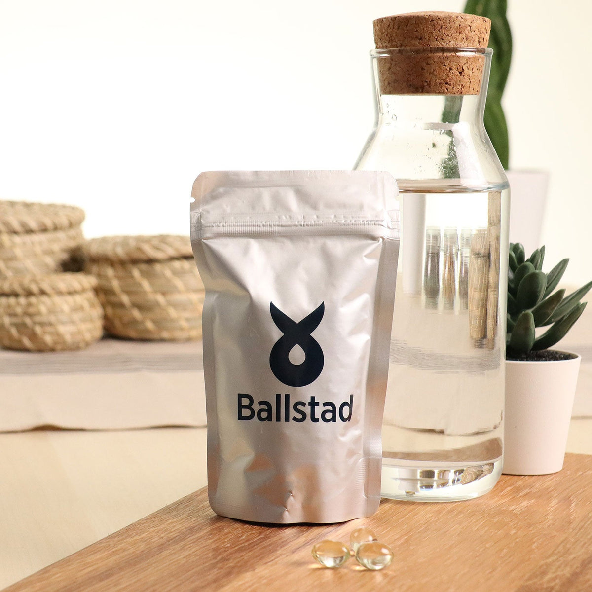 Ballstad-Nachfüllbeutel mit Kapseln neben einem Glas Wasser