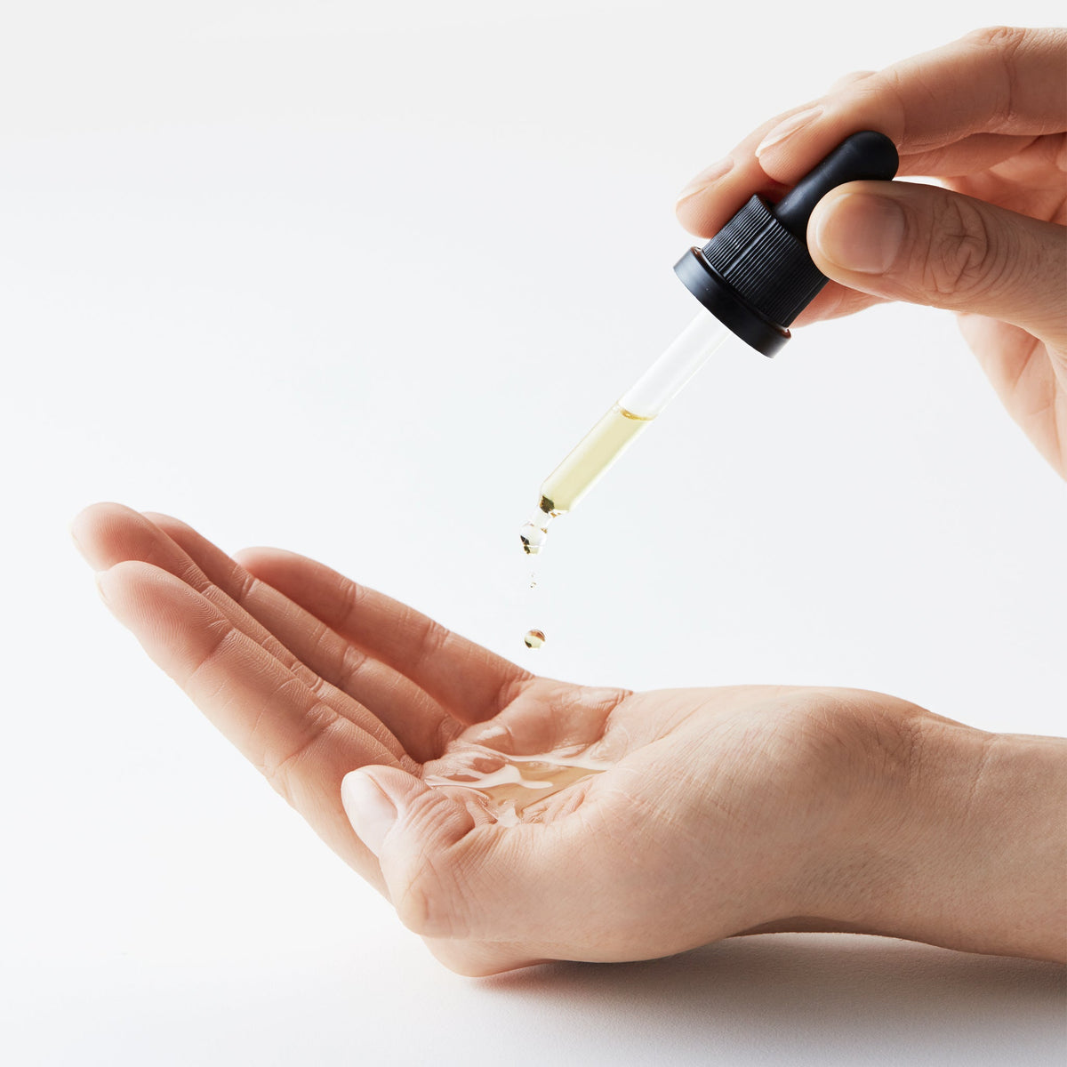 Sun Shield Drops werden mit der Pipette in eine Hand gegeben